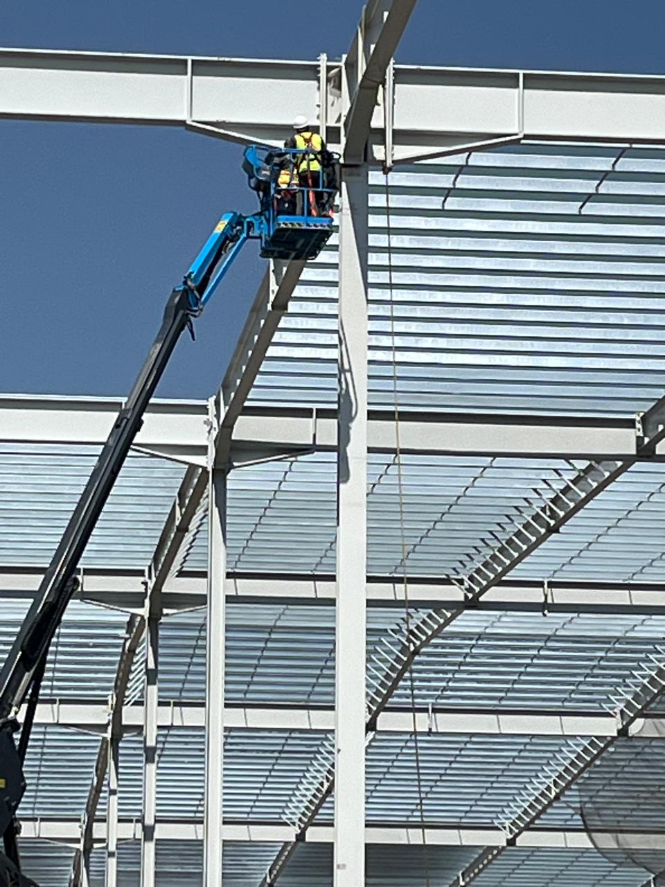 Trabajador en plataforma elevada instalando estructura de techumbre